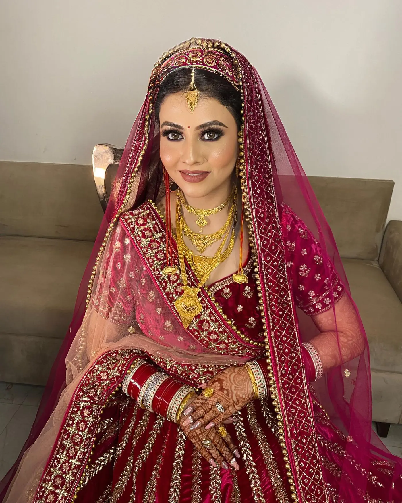 Pink Dupatta, Maroon Lehenga, Seated. Bridal makeup by Madhu Gupta at MG Makeovers, Gurugram